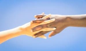 Interracial human hands crossing fingers for friendship and love Bicultural Relationships