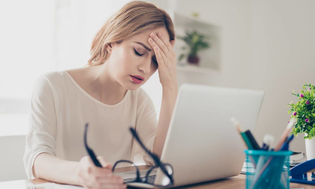 Overworked businesswoman suffering from headache and thinking how to end work chronic fatigue